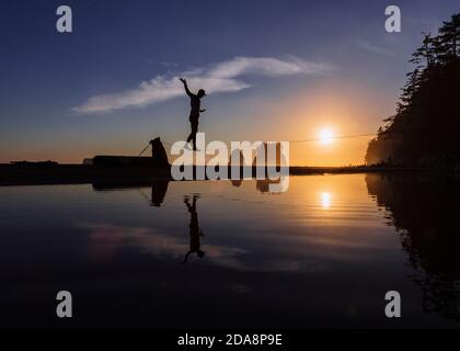 Slackliner camminare sulle acque costiere, la Push, Washington, Stati Uniti Foto Stock