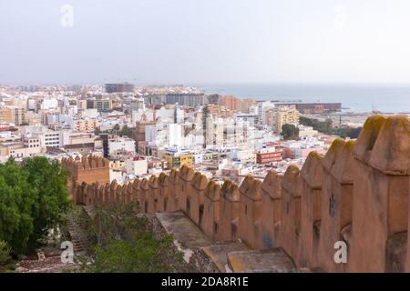 Vista aerea della città dal Mar Mediterraneo e il suo porto incorniciato da un'antica cinta muraria. Appartamenti e business buildings in città. Alcazaba, Almer Foto Stock