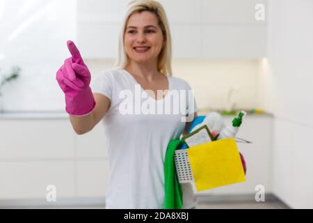 Ritratto di donna moderna sorridente con capelli lunghi a moderno home mostra l'app smart home Foto Stock