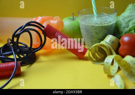 Dieta e concetto di vita sana. Melo verde e bilancia pesapersone, rubinetto di misurazione con verdure fresche, acqua pulita e attrezzature sportive per dimagrire la dieta femminile. Foto Stock