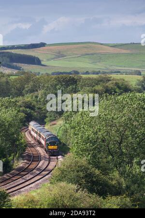 Il treno turistico 'Staycation Express' che passa da Coniston Cold, Yorkshire, trainato da una locomotiva di classe 37, 37521 Foto Stock