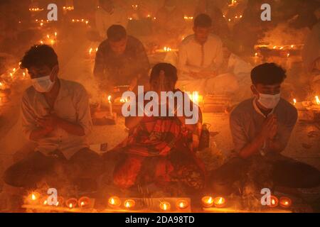 Dhaka, Bangladesh. 10 Nov 2020. Al tempo del COVID-19, i devoti indù pandemici si siedono insieme sul pavimento di un tempio per osservare Rakher Upabash a Narayanganj. I devoti indù di Shri Shri Lokanath Brahmachar Ashram celebrano Rakher Upobash un'occasione religiosa indù sul loro programma di digiuno chiamato anche Kartik Brati. (Foto di MD Abu Sufian Jewel/Pacific Press) Credit: Pacific Press Media Production Corp./Alamy Live News Foto Stock