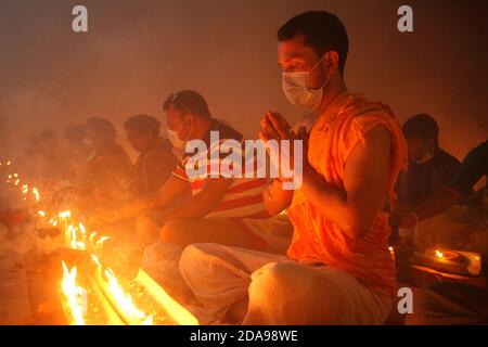 Dhaka, Bangladesh. 10 Nov 2020. Al tempo del COVID-19, i devoti indù pandemici si siedono insieme sul pavimento di un tempio per osservare Rakher Upabash a Narayanganj. I devoti indù di Shri Shri Lokanath Brahmachar Ashram celebrano Rakher Upobash un'occasione religiosa indù sul loro programma di digiuno chiamato anche Kartik Brati. (Foto di MD Abu Sufian Jewel/Pacific Press) Credit: Pacific Press Media Production Corp./Alamy Live News Foto Stock