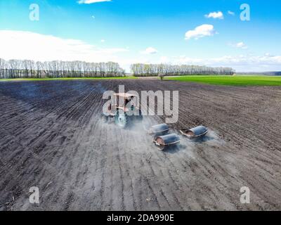 Un vecchio trattore che trasporta le lame dei rulli trainate per la semina di prodotti. Foto Stock