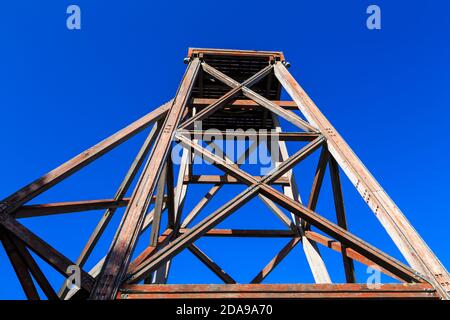 Un vecchio telaio della testa del pistoncino di legno, che si trova sulla parte superiore di un albero della miniera. Fotografato a Waihi, Nuova Zelanda Foto Stock