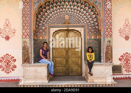 Le donne turistiche al cancello dei pavoni a Jaipur palazzo Chandra Mahal, pittura di lavoro di arte nel Rajasthan del palazzo della città, India del Nord. Palazzo Indiano della porta d'autunno Foto Stock