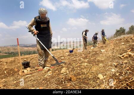 Pneumatico, Libano. 15 luglio 2010. Un team del Mines Advisory Group (MAG) è stato visto per eliminare le munizioni a grappolo non sfruttate nelle terre agricole del sud del Libano. Decenni di guerra hanno lasciato il Libano meridionale costeggiato da ordigni non sfruttati, bombe a grappolo e mine antiuomo. Il gruppo consultivo delle ONG per le miniere è attivamente coinvolto in progetti di liquidazione e di assistenza che aiutano a proteggere la popolazione locale che si affida fortemente all'agricoltura come fonte primaria di reddito. Credit: John Wreford/SOPA Images/ZUMA Wire/Alamy Live News Foto Stock