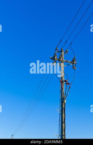 linee elettriche e collegamenti su palo di legno. pali elettrici di legno contro cielo blu. Linee elettriche e fili con cielo blu. Foto Stock