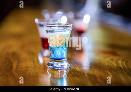 Bevande alcoliche in bicchieri da shot. Tiri di tequila, vodka, whisky. Set di cocktail alcolici in bicchieri da shot. Scatti colorati al club. Alcolico Foto Stock