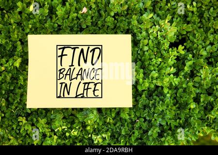 Citazione motivazionale trovare l'equilibrio nella vita scritta su carta in un giardino in natura. Concetto di benessere. Foto Stock