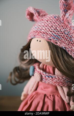 Primo piano fuoco selettivo sugli occhi di un tessuto fatto a mano bambola con capelli naturali e vestiti in maglia Foto Stock