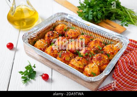 Polpette in salsa di pomodoro cotte in un contenitore di alluminio. Piatto di carne dietetica. Foto Stock