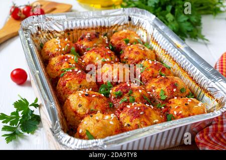 Polpette in salsa di pomodoro cotte in un contenitore di alluminio. Piatto di carne dietetica. Foto Stock