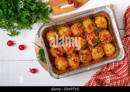 Polpette in salsa di pomodoro cotte in un contenitore di alluminio. Piatto di carne dietetica. Vista dall'alto Foto Stock