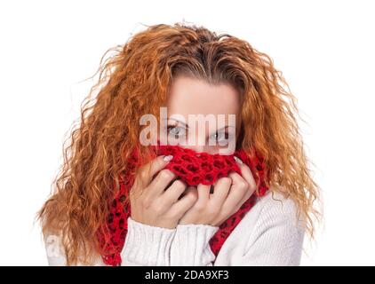 la ragazza dai capelli rossi copre il viso con una sciarpa rossa isolata bianco Foto Stock