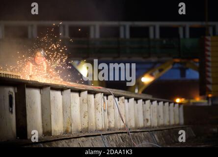 10 novembre 2020, Brandeburgo, Birkenwerder: Lavoratori che saldano su un ponte d'acciaio sul cantiere dell'autostrada A10 vicino allo svincolo di Birkenwerder. Il lavoro notturno era in preparazione per il sollevamento di un ponte di acciaio del peso di circa 205 tonnellate e di un ponte di acciaio del peso di circa 180 tonnellate per il collegamento ferroviario o ferroviario suburbano tra Oranienburg e Hohen-Neuendorf. La costruzione sostitutiva dell'impresa comune (ARGE) Havellandautobahn GmbH fa parte dell'espansione dell'autostrada A10 e richiede la completa chiusura dell'autostrada dallo svincolo di Pankow fino al 16.11.2020. Foto Stock