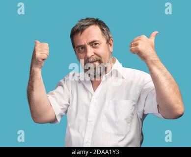 L'uomo di successo mostra i pollici su isolato su sfondo blu Foto Stock