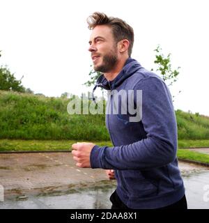 Ritratto laterale di attraente vecchio corridore maschile sulla strada Foto Stock