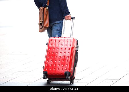 Vista posteriore ritratto dell'uomo che cammina con borsa da viaggio accesa la strada Foto Stock
