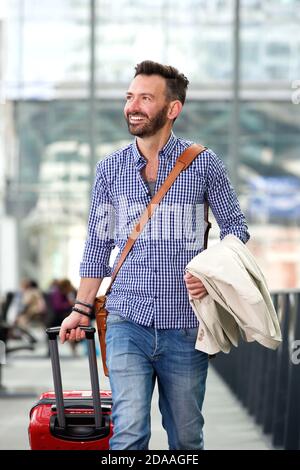 Ritratto di un uomo maturo sorridente che viaggia con valigia Foto Stock