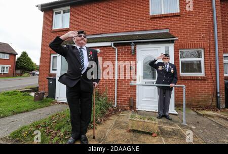 Bournemouth, Regno Unito. 11 Novembre 2020. Colin Gould, 76 anni, presidente del ramo di Bournemouth della Royal Army Service Corps Association , a sinistra, si unisce a David Comer, 90 anni, veterano della crisi di Suez, mentre si trova alle porte della sua casa a Bournemouth, Dorset, per osservare due minuti di silenzio nel giorno dell'armistizio. Credit: Richard Crease/Alamy Live News Foto Stock