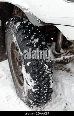 Chiocciate la ruota invernale con punte in ferro per terreni fangosi e innevati. Messa a fuoco superficiale. Foto Stock