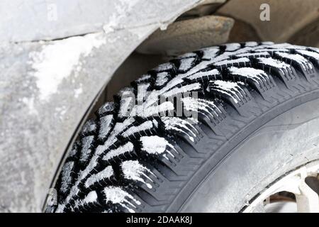 Chiocciate la ruota invernale con punte in ferro per terreni fangosi e innevati. Messa a fuoco superficiale. Foto Stock