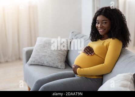 Felice africano che si aspetta signora passare il tempo a casa, copia spazio Foto Stock