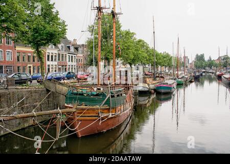 Magazzini e vecchie navi a vela ormeggiate lungo il canale Noorderhaven (Porto Nord) a Groningen, Paesi Bassi. Foto Stock