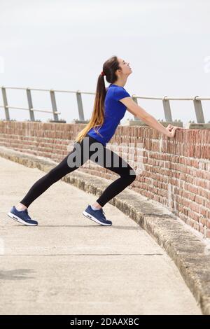 Ritratto di attraente giovane atleta in stretch esterno Foto Stock