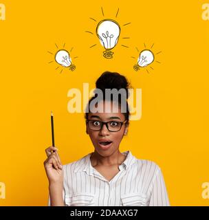 Soluzioni Genius Problem. Collage con scioccata donna nera che punta in su alle lampadine sopra la sua testa, sfondo giallo Foto Stock