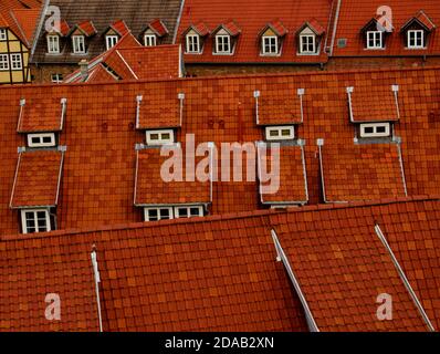 Un modello di tetti rossi con vecchie finestre in un grande città Foto Stock