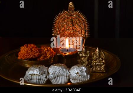 Lit, Goddess Lakshmi lampada di ottone/Lakshmi, Ganesh figurine/fiori di marigolo/ladoo-Diwali festival Foto Stock