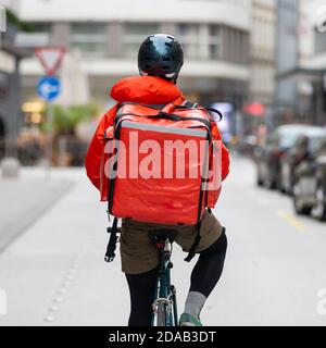 Corriere in bicicletta che consegna cibo in città. Foto Stock