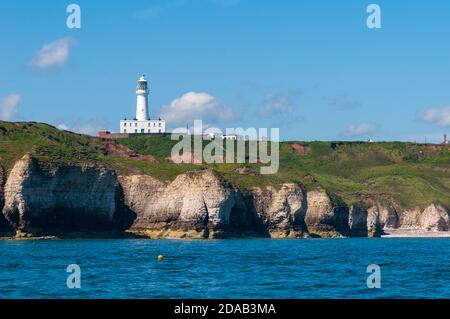 Il faro di Flamborough Head sopra le scogliere di gesso viste dal mare. Flamborough, East Yorkshire. Giugno. Foto Stock