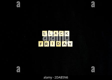 Black Friday scritto in lettere di legno su sfondo nero, vendite, vendite vacanze, vista dall'alto, layout piatto, riduzione dei prezzi Foto Stock