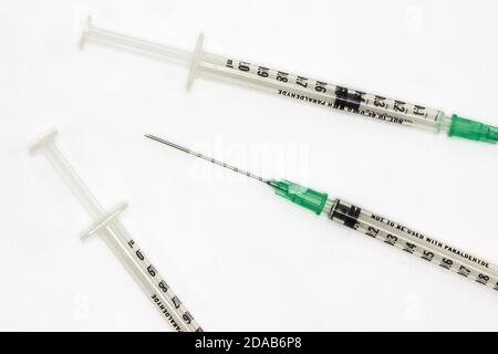 Aghi ipodermici su sfondo bianco. Siringhe per la vaccinazione durante la pandemia del coronavirus Foto Stock