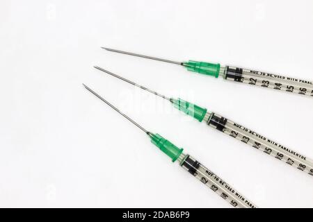 Aghi ipodermici su sfondo bianco. Siringhe per la vaccinazione durante la pandemia del coronavirus Foto Stock