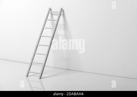 Scala di legno vicino al muro in una stanza bianca vuota Foto Stock