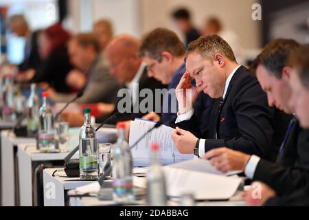 Erfurt, Germania. 11 Nov 2020. Mario Voigt (2° da destra), leader della Turingia della fazione del CDU, siede tra gli altri membri del parlamento nella sala del parco dello Stadio Steigerwald, dove ha inizio la sessione del parlamento di Stato di tre giorni. L'ordine del giorno comprende un'ora d'attualità per commemorare il 9 novembre, modifiche al regolamento edilizio della Turingia, modifiche al Thuringia Higher Education Act, nonché la garanzia della prossima generazione di professionisti medici nelle aree rurali e progetti di leggi sul finanziamento delle scuole indipendenti. Credit: Martin Schutt/dpa-Zentralbild/dpa/Alamy Live News Foto Stock