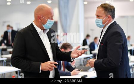 Erfurt, Germania. 11 Nov 2020. Thomas Kemmerich (l, FDP), ex Ministro Presidente della Turingia, e Mario Voigt, capo della fazione della CDU della Turingia, si comunicano tra loro nella sala del parco dello Steigerwaldstadion, dove ha inizio la sessione del parlamento di Stato di tre giorni. L'ordine del giorno comprende un'ora d'attualità per commemorare il 9 novembre, modifiche al codice edilizio della Turingia, modifiche alla legge sull'istruzione superiore della Turingia, protezione della prossima generazione di professionisti medici nelle aree rurali e progetti di leggi sul finanziamento delle scuole indipendenti. Credit: Martin Schutt/dpa-Zentralbild/dpa/Alamy Live News Foto Stock