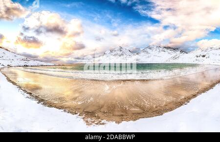 Fantastica vista invernale della spiaggia di Vik al tramonto con molta neve e cime innevate vicino a Leknes. Ubicazione: Leknes, Vestvagoy, Lofotens, NOR Foto Stock