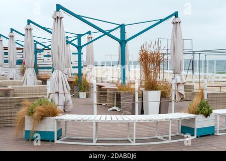 Tavoli e sedie vuoti di un ristorante su una terrazza affacciata sul mare. Cafe con vista mare chiuso per quarantena o inverno. Bel posto dove mangiare Foto Stock