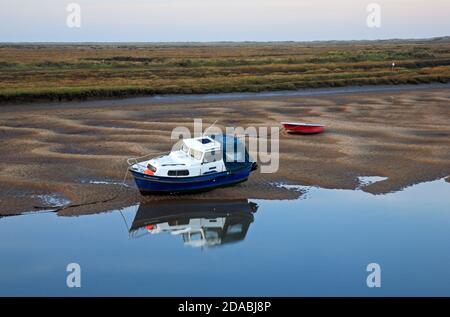 Un varo e una piccola barca in barca a Overy Creek a bassa acqua nel Nord Norfolk a Burnham Overy Staithe, Norfolk, Inghilterra, Regno Unito. Foto Stock