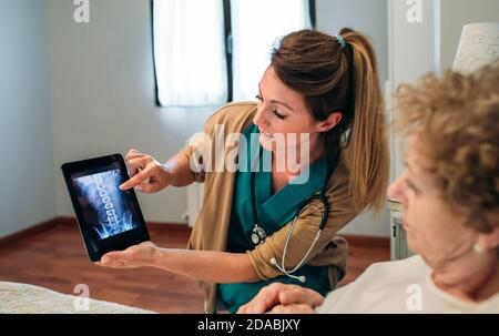 Medico di sesso femminile che mostra una radiografia sulla compressa Foto Stock