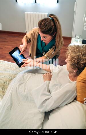 Medico di sesso femminile che mostra una radiografia sulla compressa Foto Stock