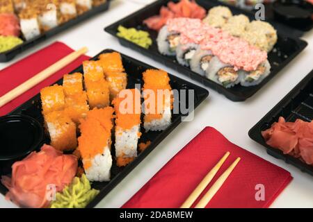 Un set di sushi colorati su un tavolo bianco con vino in una sala accogliente. Foto Stock