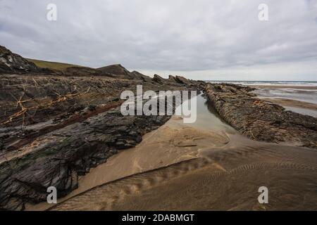 Alternando bande di arenaria e scali formano i lati ripidi e il pavimento di Crackington HavenRipples e farine rivelano questi strati di essere turbiditi. Foto Stock