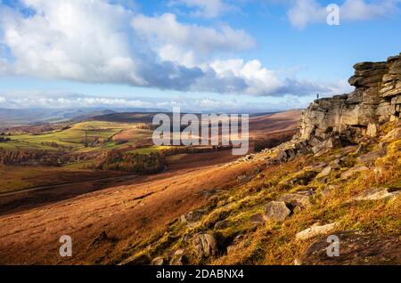 Walker in lontananza su Stanage Edge vicino ad Hathersage Derbyshire Peak District National Park Derbyshire Inghilterra GB Europa Foto Stock