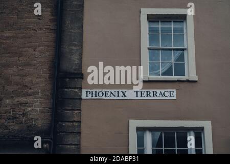 Cartello con il nome della strada su un muro di mattoni di un edificio sulla Phoenix Terrace a Frome, Somerset, UK. Foto Stock